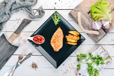 Susam, patates ve soslu Fırında tavuk fileto. Ahşap bir arka plan üzerinde. Üstten görünüm. Kopya alanı.