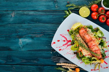 Fırında somon ve sebze salatası. Ahşap bir arka plan üzerinde. Üstten görünüm. Kopya alanı.