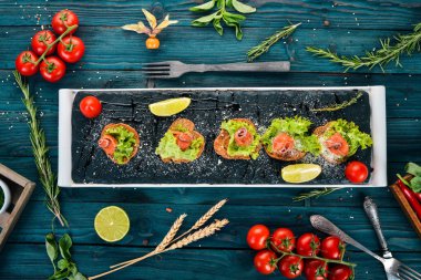 Sandviç somon ve salata ile bırakır. Ahşap bir arka plan üzerinde. Üstten görünüm. Kopya alanı.