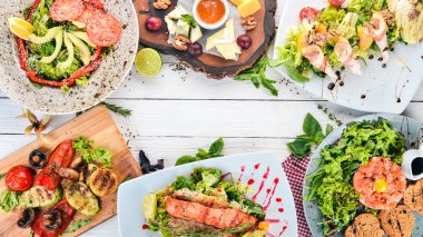 Bir dizi yemek. Tartar, peynir, salata ve sebze. Ahşap bir arka plan üzerinde. Üstten görünüm. Kopya alanı.