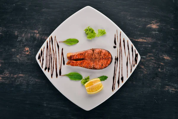 Limon ile pişmiş somon fileto. Kırmızı balık. Ahşap bir arka plan üzerinde. Üstten görünüm. Ücretsiz kopya alanı.