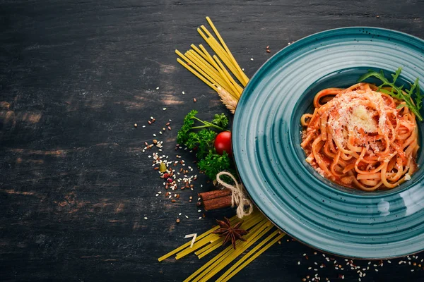 Domatesli makarna makarna. Ahşap bir arka plan üzerinde. İtalyan mutfağı. Üstten Görünüm. Kopya alanı.