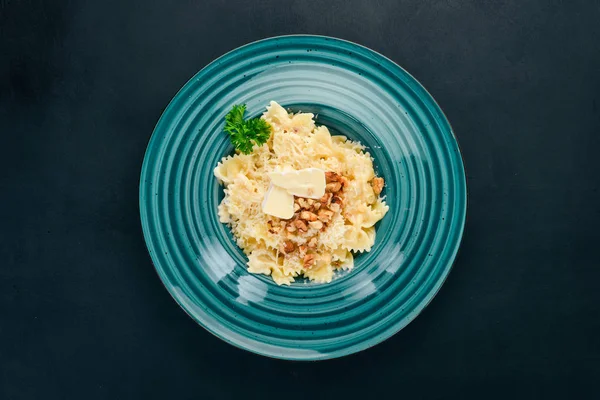 Brie peyniri ve fındık ile farfalle makarna. İtalyan mutfağı. Ahşap bir arka plan üzerinde. Üstten görünüm. Kopya alanı.