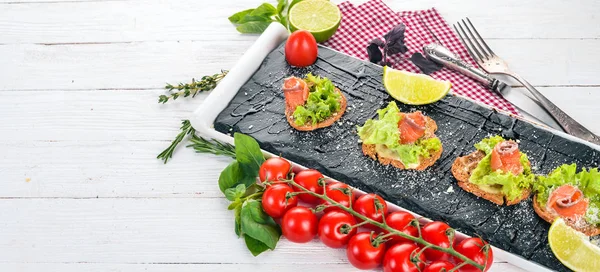 Sandviç somon ve salata ile bırakır. Ahşap bir arka plan üzerinde. Üstten görünüm. Kopya alanı.