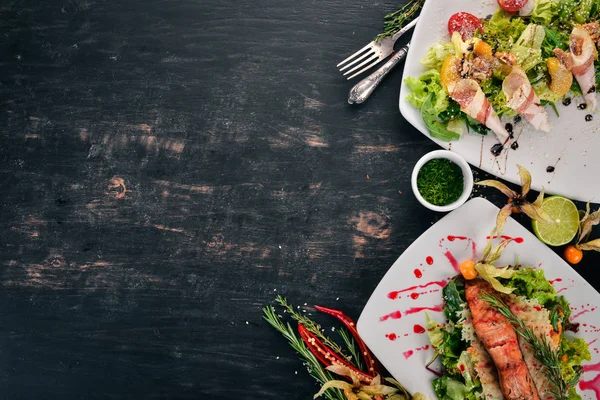 Food. A set of delicious salad with avocado and vegetables. On a wooden background. Top view. Copy space.