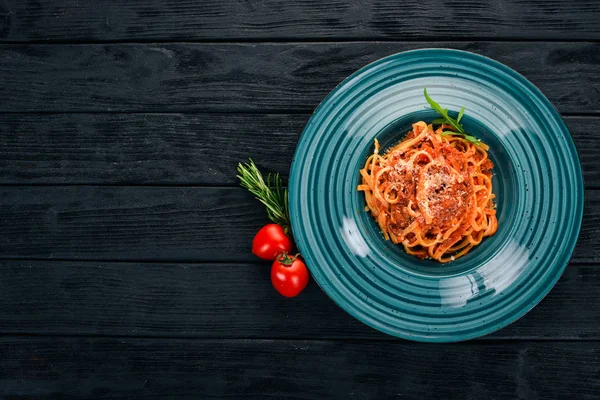 Domatesli makarna makarna. Ahşap bir arka plan üzerinde. İtalyan mutfağı. Üstten Görünüm. Kopya alanı.