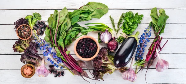 Purple food. Fresh vegetables and berries. On a white wooden background. Top view. Copy space.