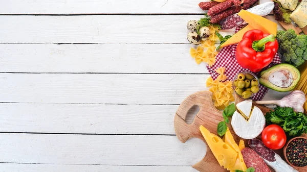 Sosis, peynir ve taze sebze ürün yelpazesine. Beyaz ahşap zemin üzerinde. Üstten görünüm. Kopya alanı.