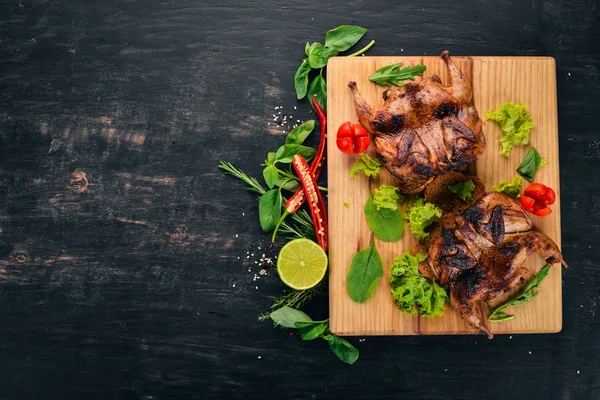 Ahşap oyun tahtası sebzeli fırında bıldırcın. Ahşap bir arka plan üzerinde. Üstten görünüm. Kopya alanı.