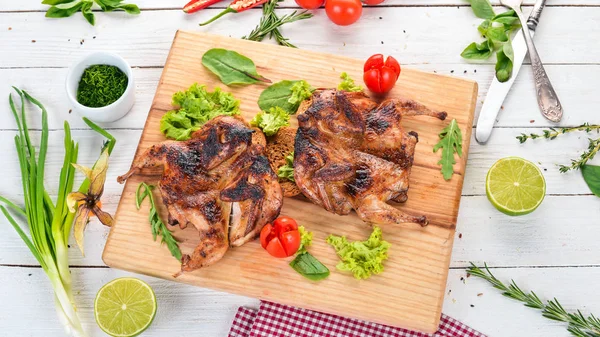 Ahşap oyun tahtası sebzeli fırında bıldırcın. Ahşap bir arka plan üzerinde. Üstten görünüm. Kopya alanı.