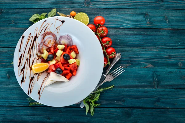 Brie peyniri ile Yunan sebze salatası. Ahşap bir arka plan üzerinde. Üstten görünüm. Kopya alanı.