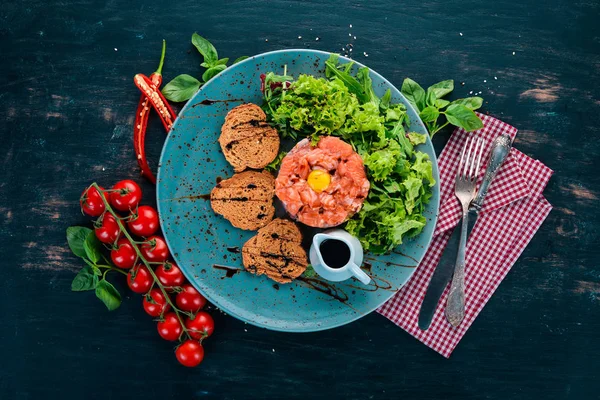 Tartar somon ve avokado. Ahşap bir arka plan üzerinde. Üstten görünüm. Kopya alanı