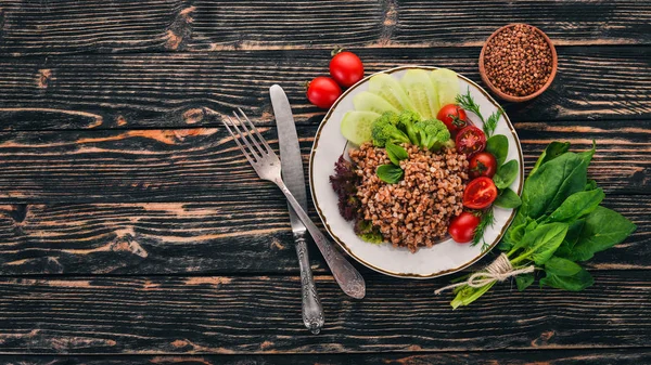 Karabuğday salatalık, brokoli ve domates ile. Ahşap bir arka plan üzerinde. Üstten görünüm. Kopya alanı.