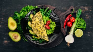 Omlet sebze ve avokado. Kızarmış yumurta. Ahşap bir arka plan üzerinde. Üstten görünüm. Ücretsiz kopya alanı.