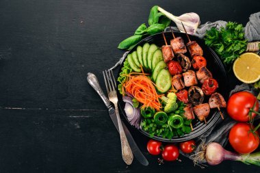 Bir tabak taze sebze ile pişmiş dana eti şiş kebap. Ahşap bir arka plan üzerinde. Üstten görünüm. Kopya alanı.