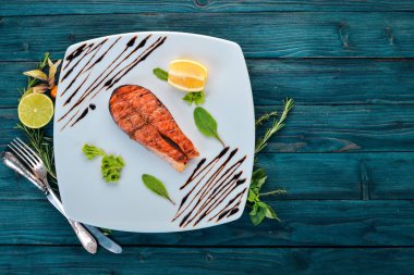 Limon ile pişmiş somon fileto. Kırmızı balık. Ahşap bir arka plan üzerinde. Üstten görünüm. Ücretsiz kopya alanı.