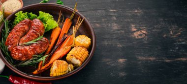 Izgara sosis. Pişmiş Mısır ve patates gibiydik. Ahşap bir arka plan üzerinde. Üstten görünüm. Kopya alanı.