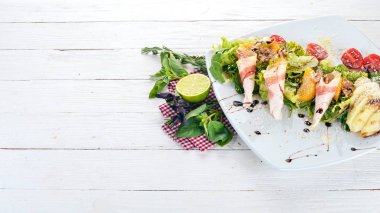 Taze salata domuz pastırması, avokado ve domates. Ahşap bir arka plan üzerinde. Üstten görünüm. Kopya alanı.