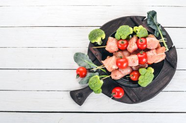 Domates ve sebzeler çiğ tavuk şiş. Kebap. Ahşap bir arka plan üzerinde. Üstten görünüm. Kopya alanı.