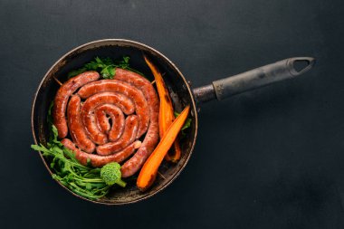 Baharat ile bir tavada kızarmış tavuk sosis. Ahşap bir arka plan üzerinde. Üstten görünüm. Kopya alanı.