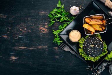 Siyah burger et, soğan ve marul. Ahşap bir arka plan üzerinde. Üstten görünüm. Kopya alanı.