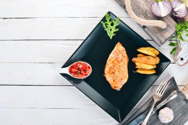 Susam, patates ve soslu Fırında tavuk fileto. Ahşap bir arka plan üzerinde. Üstten görünüm. Kopya alanı.