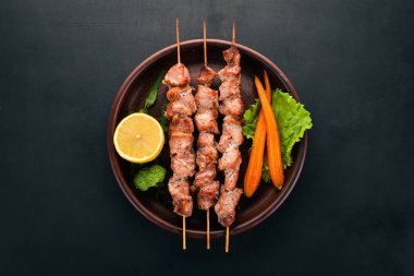Bir tabakta et pişmiş şiş. Ahşap bir arka plan üzerinde. Üstten görünüm. Kopya alanı.