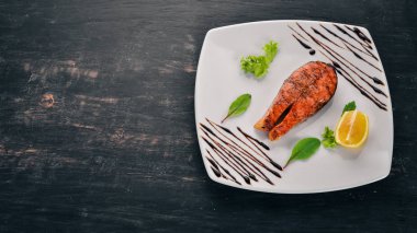 Limon ile pişmiş somon fileto. Kırmızı balık. Ahşap bir arka plan üzerinde. Üstten görünüm. Ücretsiz kopya alanı.