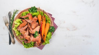 Sebze ve havuç ile ızgara tavuk kanatları. Ahşap bir arka plan üzerinde. Üstten görünüm. Kopya alanı.