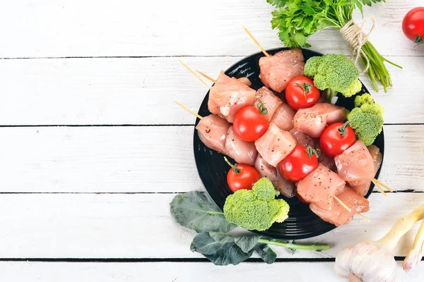 Domates ve sebzeler çiğ tavuk şiş. Kebap. Ahşap bir arka plan üzerinde. Üstten görünüm. Kopya alanı.