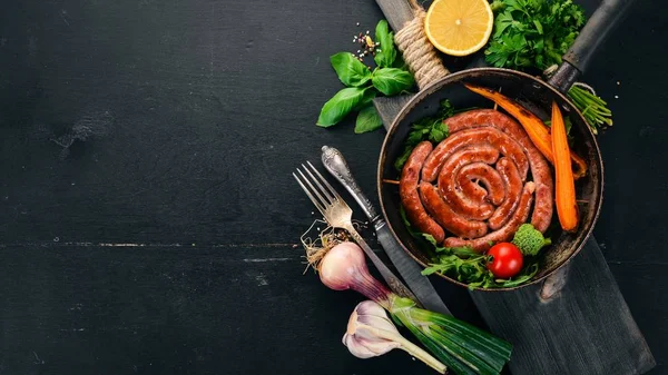 Baharat ile bir tavada kızarmış tavuk sosis. Ahşap bir arka plan üzerinde. Üstten görünüm. Kopya alanı.