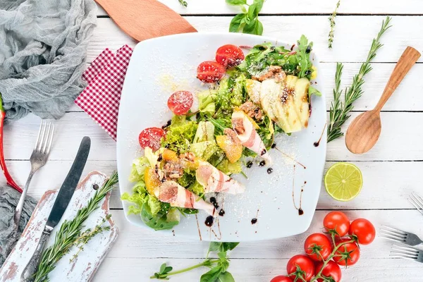 Taze salata domuz pastırması, avokado ve domates. Ahşap bir arka plan üzerinde. Üstten görünüm. Kopya alanı.