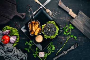 Siyah burger et, soğan ve marul. Ahşap bir arka plan üzerinde. Üstten görünüm. Kopya alanı.