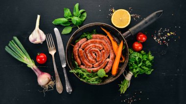 Baharat ile bir tavada kızarmış tavuk sosis. Ahşap bir arka plan üzerinde. Üstten görünüm. Kopya alanı.