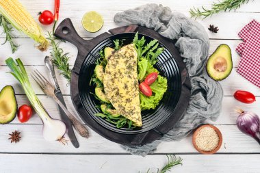 Omlet sebze ve avokado. Kızarmış yumurta. Ahşap bir arka plan üzerinde. Üstten görünüm. Ücretsiz kopya alanı.