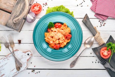 Farfalle makarna domates ve parmesan peyniri. İtalyan mutfağı. Ahşap bir arka plan üzerinde. Üstten görünüm. Kopya alanı.