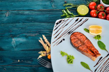 Limon ile pişmiş somon fileto. Kırmızı balık. Ahşap bir arka plan üzerinde. Üstten görünüm. Ücretsiz kopya alanı.