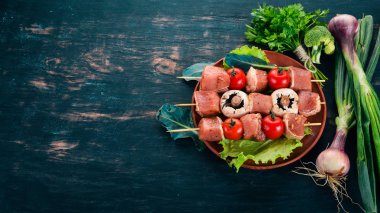 Ham şiş bir et bir plaka üzerinde. Ahşap bir arka plan üzerinde. Üstten görünüm. Kopya alanı.