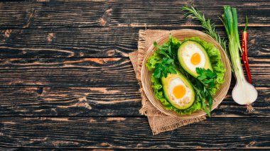 Yumurta ile pişmiş avokado. Sağlıklı gıda. Ahşap bir arka plan üzerinde. Üstten görünüm. Kopya alanı.