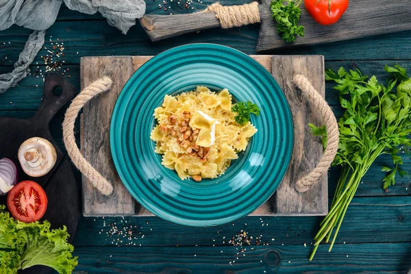 Brie peyniri ve fındık ile farfalle makarna. İtalyan mutfağı. Ahşap bir arka plan üzerinde. Üstten görünüm. Kopya alanı.