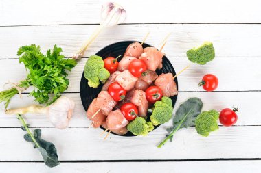 Domates ve sebzeler çiğ tavuk şiş. Kebap. Ahşap bir arka plan üzerinde. Üstten görünüm. Kopya alanı.