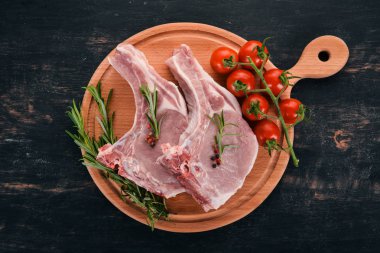 Kemik baharatlar ve sebzeler çiğ biftek. Ahşap bir arka plan üzerinde. Üstten görünüm. Kopya alanı.