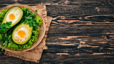 Yumurta ile pişmiş avokado. Sağlıklı gıda. Ahşap bir arka plan üzerinde. Üstten görünüm. Kopya alanı.