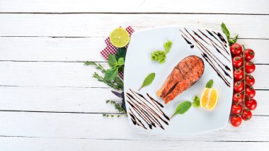 Limon ile pişmiş somon fileto. Kırmızı balık. Ahşap bir arka plan üzerinde. Üstten görünüm. Ücretsiz kopya alanı.