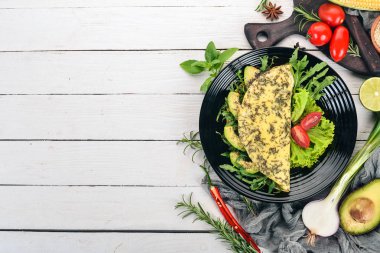 Omlet sebze ve avokado. Kızarmış yumurta. Ahşap bir arka plan üzerinde. Üstten görünüm. Ücretsiz kopya alanı.