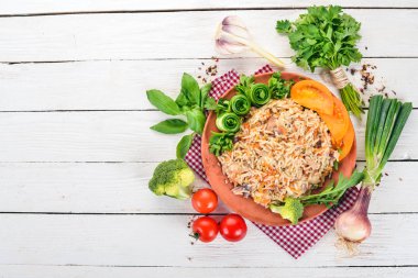 Et ve sebze bir plaka üzerinde plov pilav. Özbek mutfağı. Ahşap bir arka plan üzerinde. Üstten görünüm. Kopya alanı.