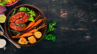 Izgara sosis. Pişmiş Mısır ve patates gibiydik. Ahşap bir arka plan üzerinde. Üstten görünüm. Kopya alanı.