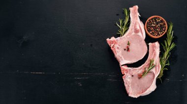 Kemik baharatlar ve sebzeler çiğ biftek. Ahşap bir arka plan üzerinde. Üstten görünüm. Kopya alanı.