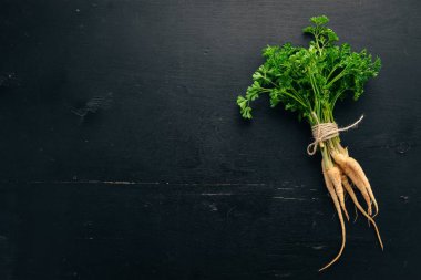 Taze yeşil maydanoz. Kök maydanoz. Ahşap bir arka plan üzerinde. Üstten görünüm. Kopya alanı.