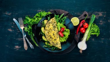 Omlet sebze ve avokado. Kızarmış yumurta. Ahşap bir arka plan üzerinde. Üstten görünüm. Ücretsiz kopya alanı.